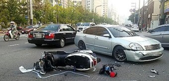흰색-승용차와-오토바이가-부딛쳐-오토바이가-넘어지고-크게-파손된-모습
