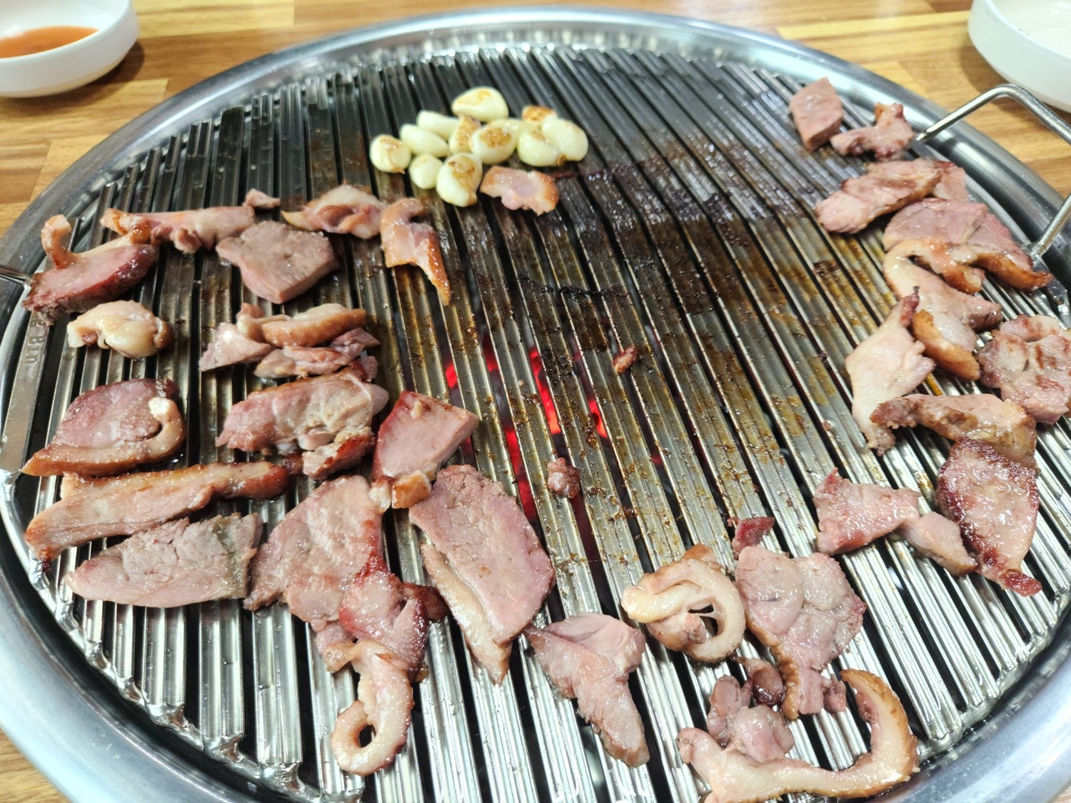고기와 마늘이 불판 위에서 노릇노릇하게 익은 상태이다