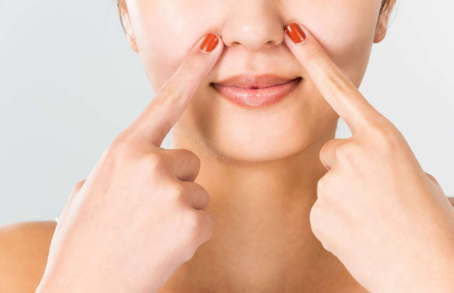 코를 가리키는 여자.