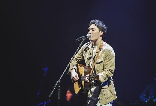 김필이-무대에서-기타를-치며-노래를-부르고-있는-사진