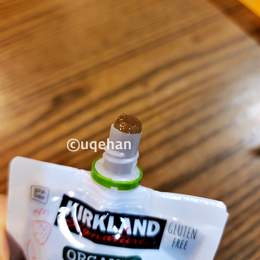 커클랜드 시그니춰 유기농 프루트 앤 베제터블 파우치 (사과 / 딸기 / 시금치) 내용물이 입구에 살짝 나와있다.