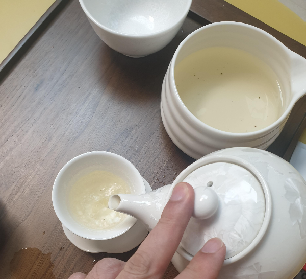 차판위에 다완, 찻잔, 퇴수기, 공도배가 보인다. 퇴수기에는 예열용 물을 버린 상태, 다완으로 찻잔을 채우고 있다.