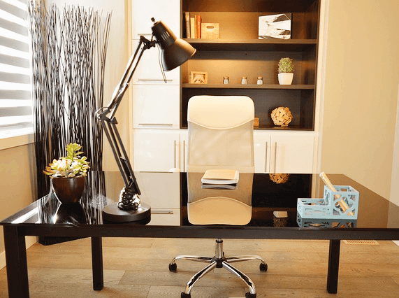 헤드헌터가 일하는 책상이 있다. 고동색의 세련된 사각형 책상이고 높은 전등이 놓여있다.