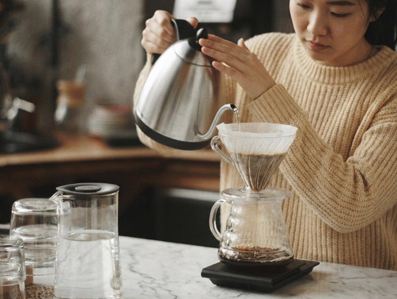 베이지색 상의를 입고 커피를 추출 중인 바리스타