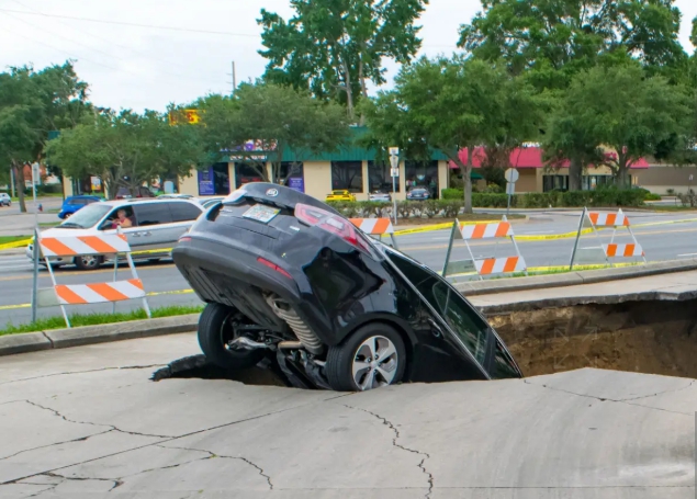 싱크홀에 자동차가 빠지는 사진