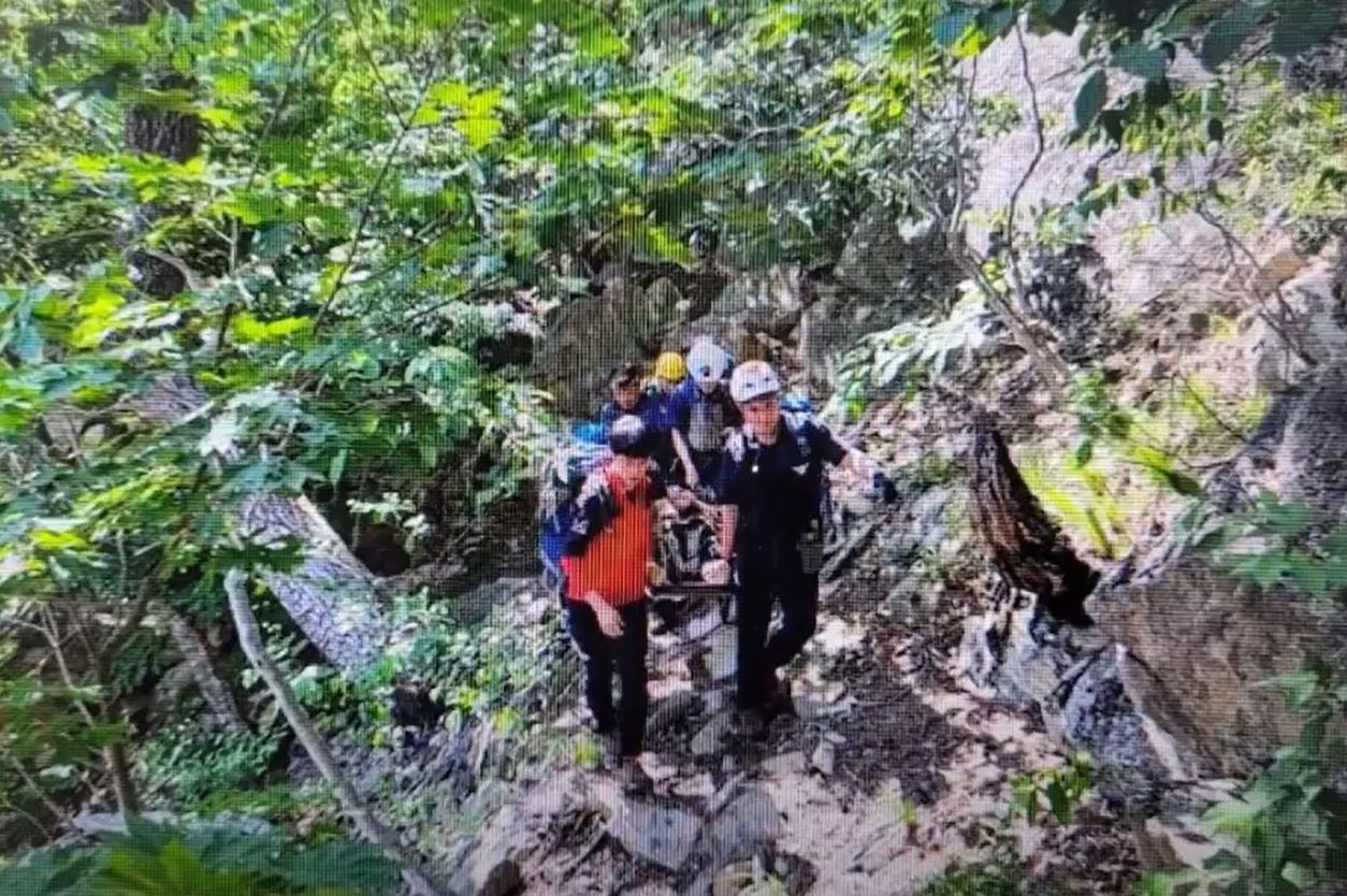 추락지점에서 부상자를 들것에 실어 헬기가 있는 장소까지 옮기는 소방대원들