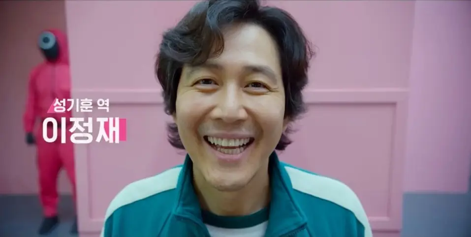 오징어게임2-
보라색 배경 검은색 웨이브 머리 이정재가 해맑게 웃는 모습