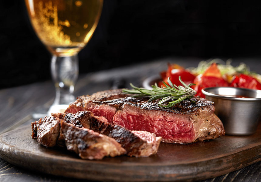 아웃백 레스토랑 테이블에 스테이크와 파스타가 차려진 모습