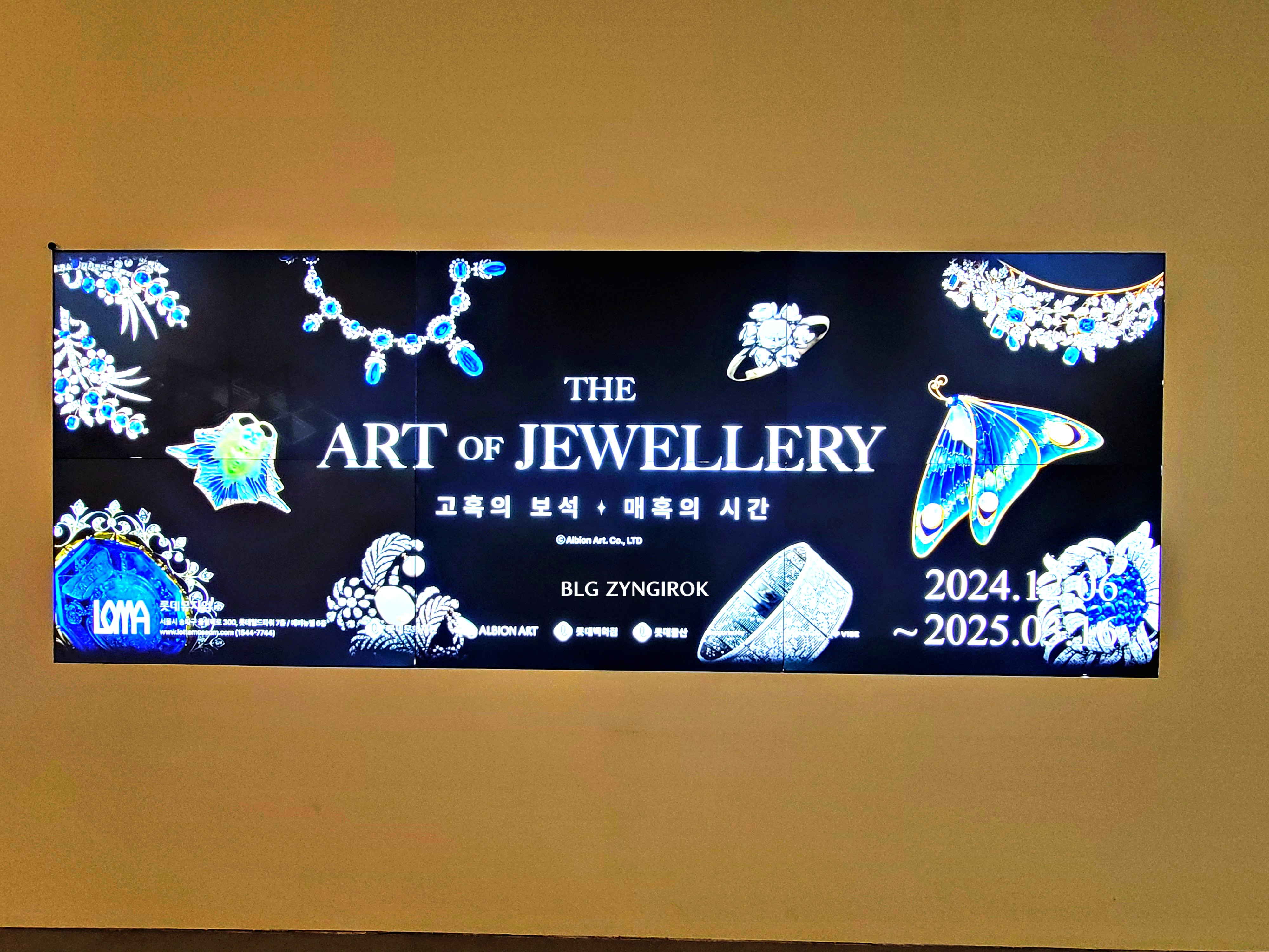 롯데타워 - 롯데뮤지엄 고혹의 보석 매혹의 시간 포스터가 디스플레이에 떠있는 모습이다.