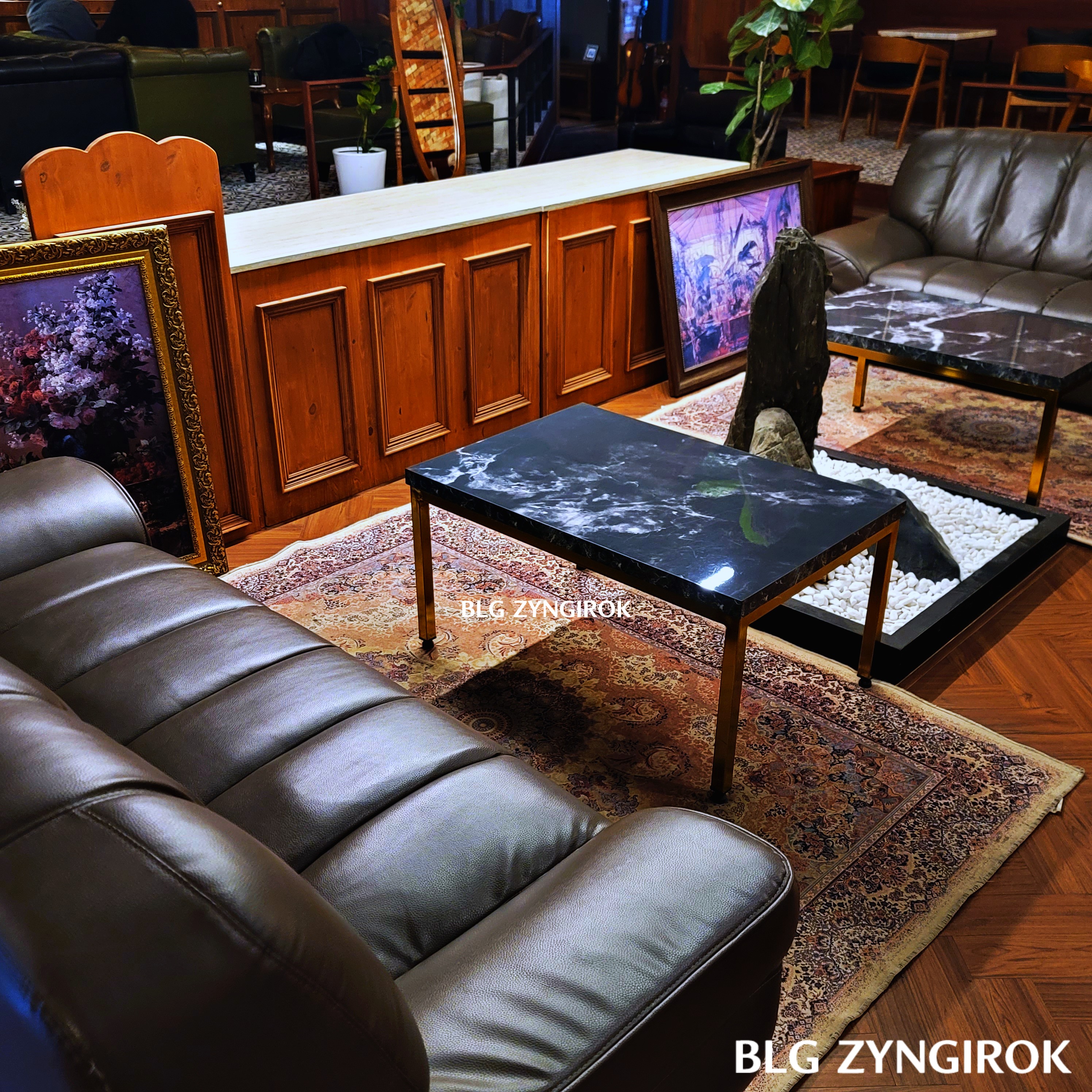 매장 정 중앙의 좌석 모습이다. 대형 소파와 두개의 테이블 사이에 돌장식이 있다.