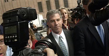 엔론의 재무책임자가 언론인들 사이로 지나가는 사진