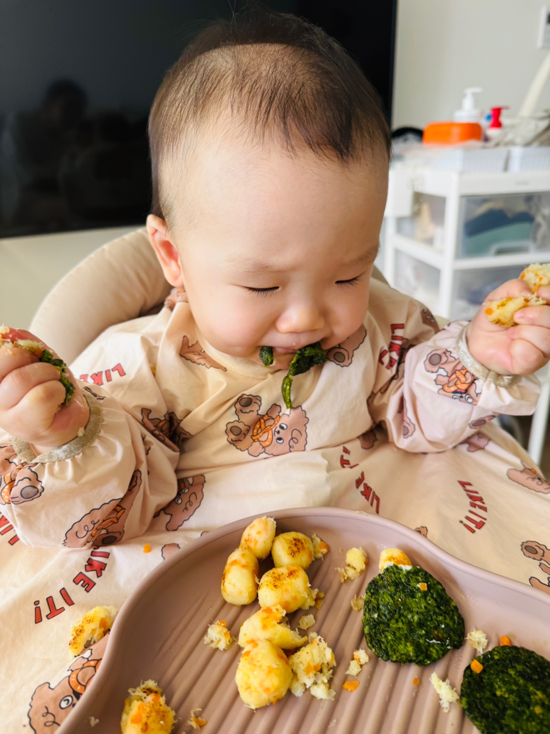 찬솔이가 손으로 생선완자를 집어들고 호기심 가득한 표정으로 바라보는 모습