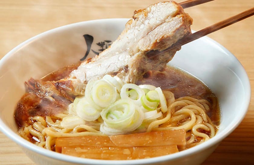 라면위에 올라가 있는 두툼한 고기를 젓가락으로 집고 있는 사진