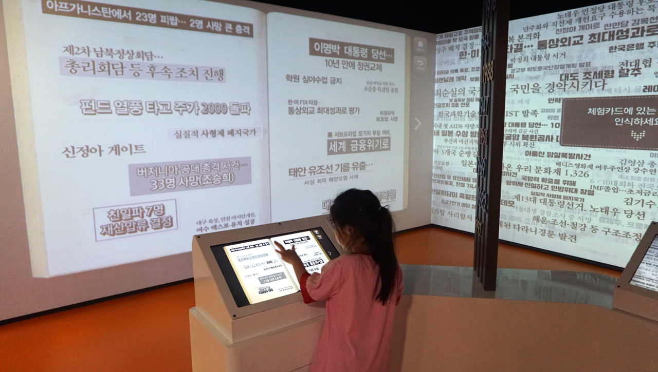 아이가 옛날 신문 스크랩 북을 보고 있다