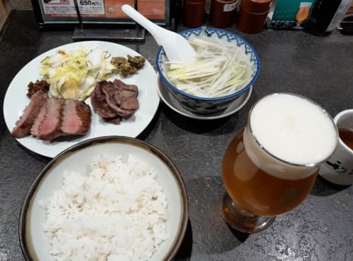 고기와 밥 그리고 스프 맥주가 테이블 위에 올려져 있다.