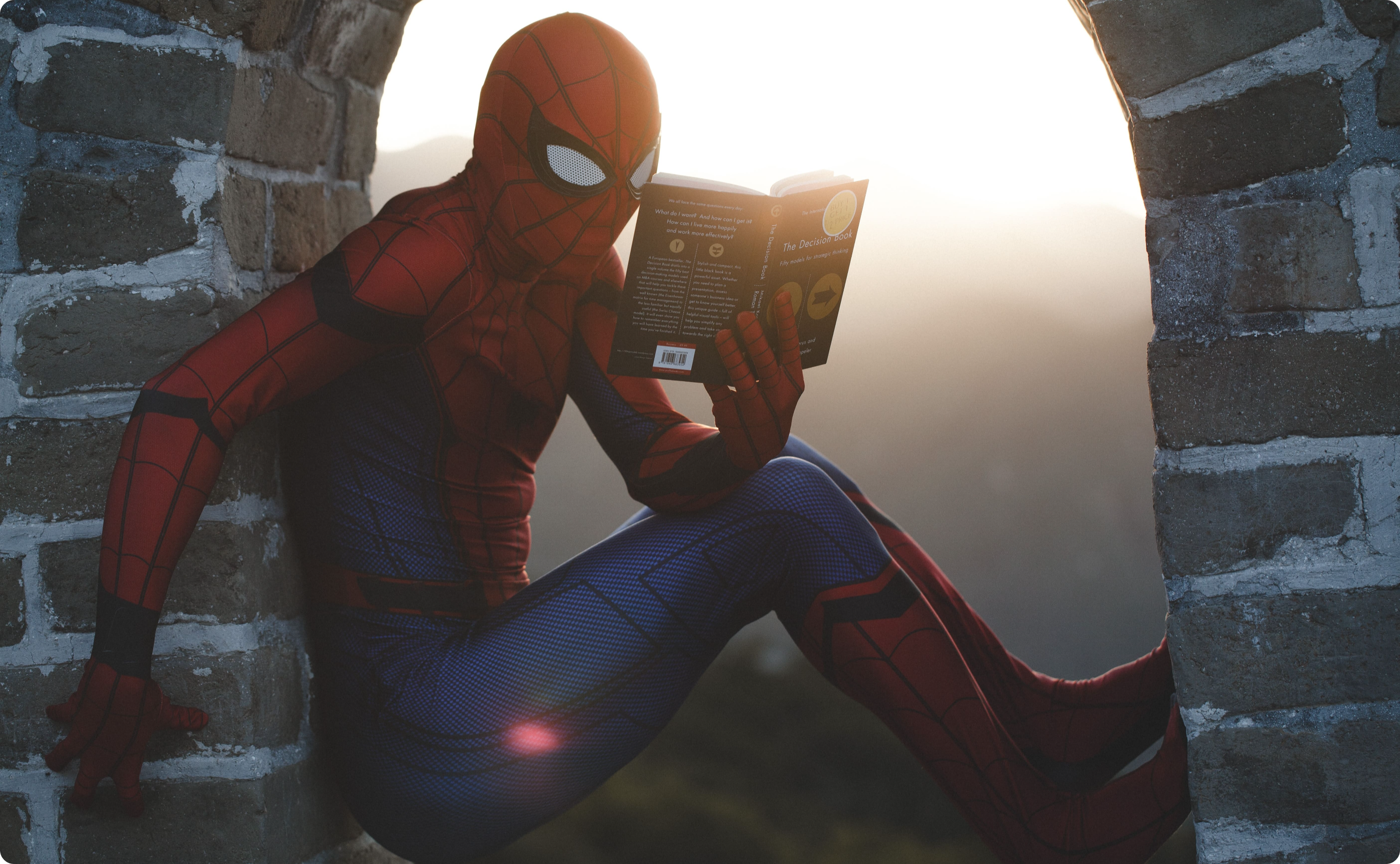 Spiderman studying with a book