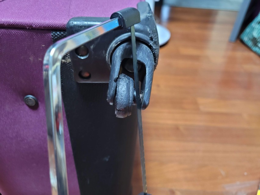 쇠톱으로 캐리어 바퀴 축을 절단하는 과정