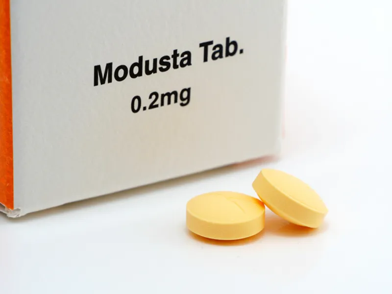 최근 출시된 저용량 두타스테리드 0.2mg 알약 또는 약 패키지 이미지. 새로운 탈모 치료 옵션을 보여줌.
