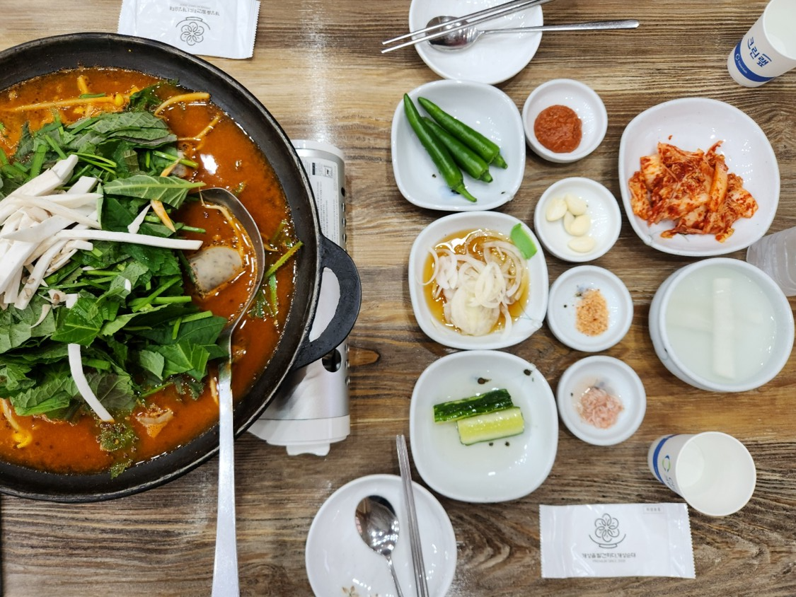 순대 전골이 반찬들과 함께 제공되어 테이블 위에 있다.