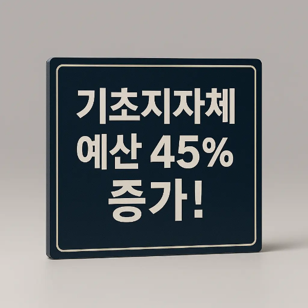 “기초지자체 예산 45% 증가!” 문구가 적힌 짙은 파란색 간판이 조명을 받으며 놓여 있는 스튜디오 이미지