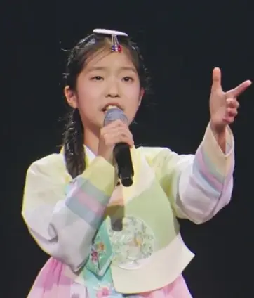 미스트롯3-
검은 무대 위 색동 저고리 한복을 입고 오른손으로 마이크를 든채 노래하고 있는 빈예서