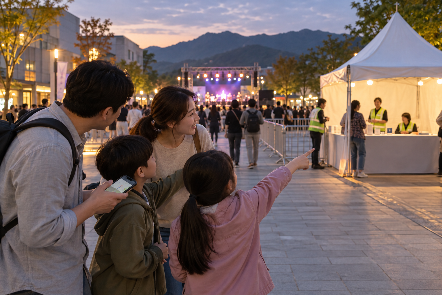 야간 축제장에서 가족이 안내 부스를 만날 장소로 정하는 모습
