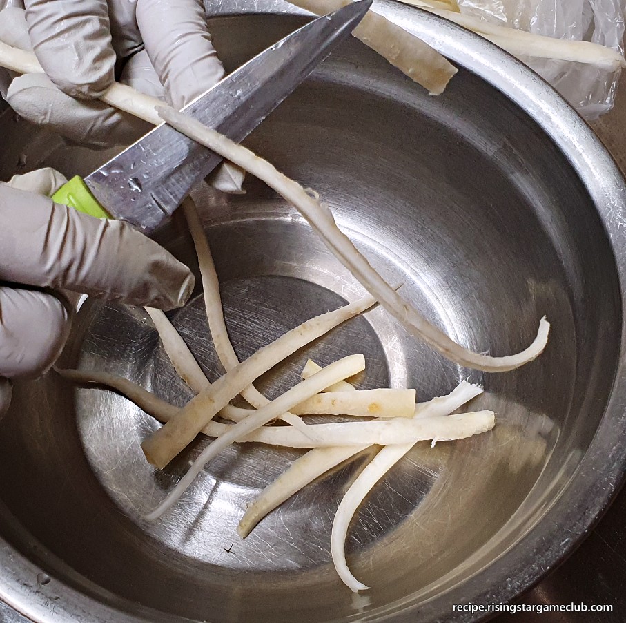도라지나물에 들어갈 도라지를 길게 어슷잘라 손질하는 사진