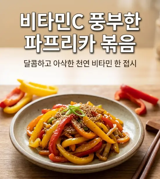 도자기 접시에 빨강&middot;노랑&middot;주황 파프리카 볶음이 담기고, 깨와 파채로 마무리한 모습. 나무 젓가락과 원목 테이블 위에서 자연광으로 촬영한 한국 가정식 반찬 스타일링