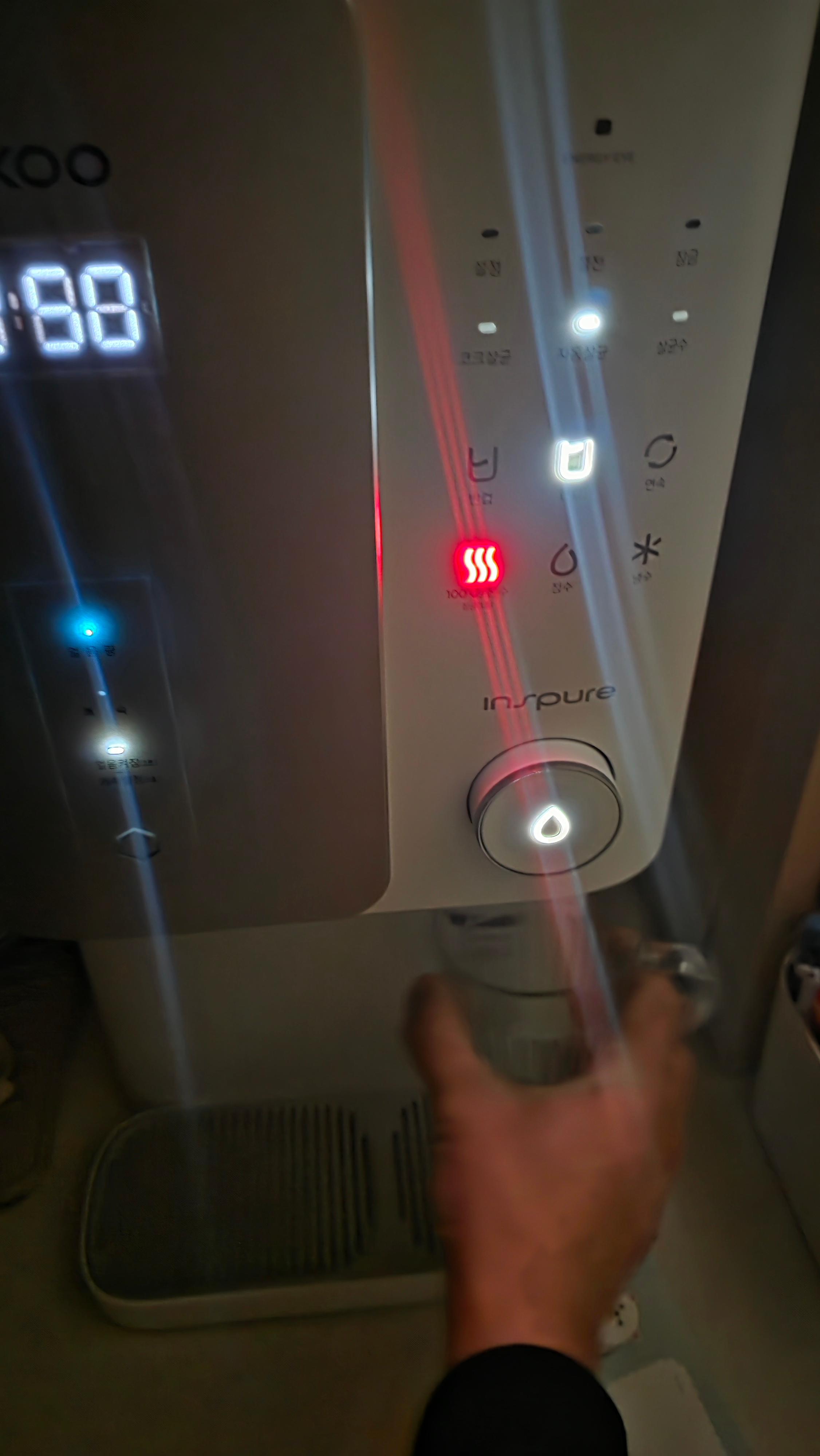 정수기에서 온수를 컵에 받고 있는 사진