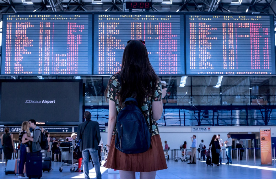 여행자가 공항에서 시간표 보는 사진