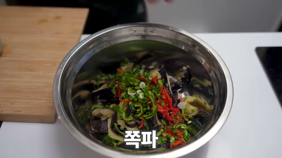 가지에 고추와 쪽파, 양념장을 넣어 버무리는 장면