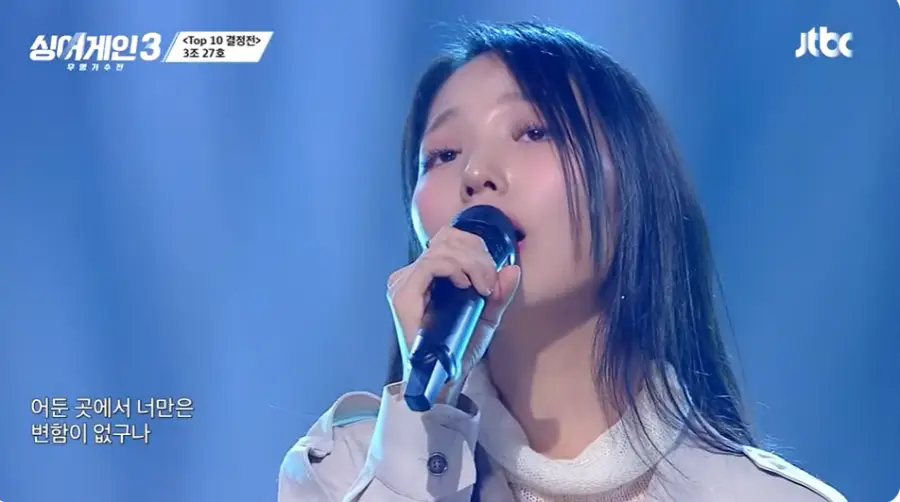 싱어게인3- 흰옷을 입은 여자가 관객을 보며 노래하는 모습