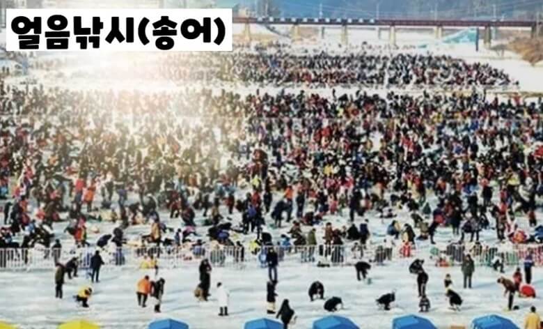 수백명의 관광객들이 얼어붙은 강의 얼음을 깨고 송어 낚시를 하고 있는 모습