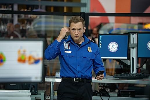 넷플릭스 영화 "Carry-On" 한 장면 : 주인공 이선 코펙이 TSA 요원 복장을 입고 등장