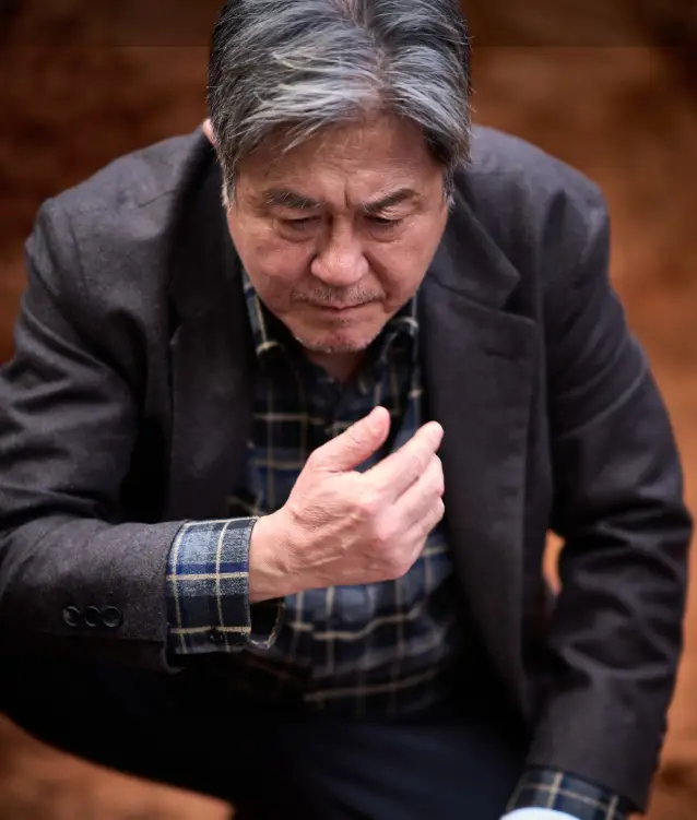 파묘- 흰머리 양복을 입고 쪼그리고 앉은채 생각중인 최민식