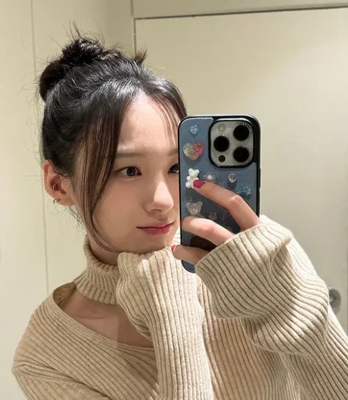 싱어게인3- 베이지색 니트를 입고 왼손으로 핸드폰을 들고 자신의 셀카를 찍고있는 66호