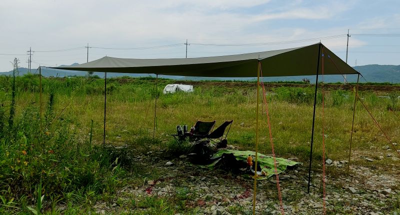 돌자갈 위에 타프를 친 사진 빨간색 스프레이로 동그라미가 쳐져있음