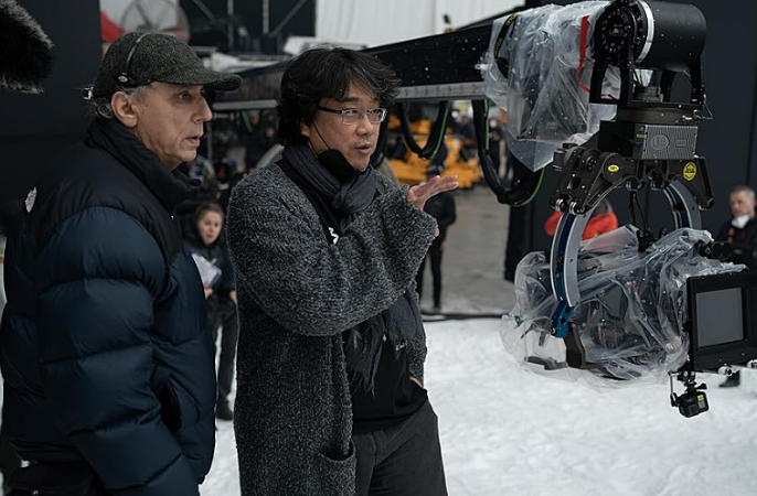 봉준호 감독이 영화 <미키17> 촬영장에서 촬영하고 있는 모습을 담은 사진