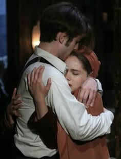 자주색-코트를-입은-여성이-와이셔츠를-입은-남성을-꼭-껴안는-모습