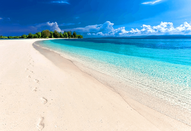 하얀 모래 해변이 있고, 오른쪽에는 하늘빛 맑은 바닷물이 있다.