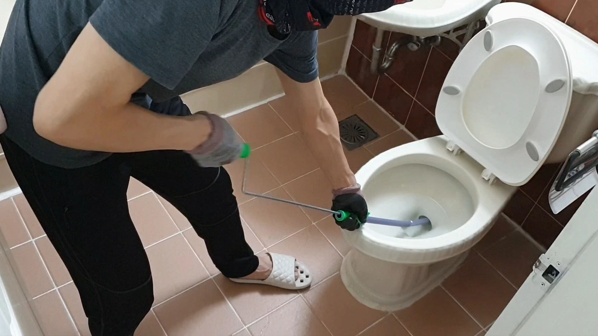 막힌 변기 뚫는 모습