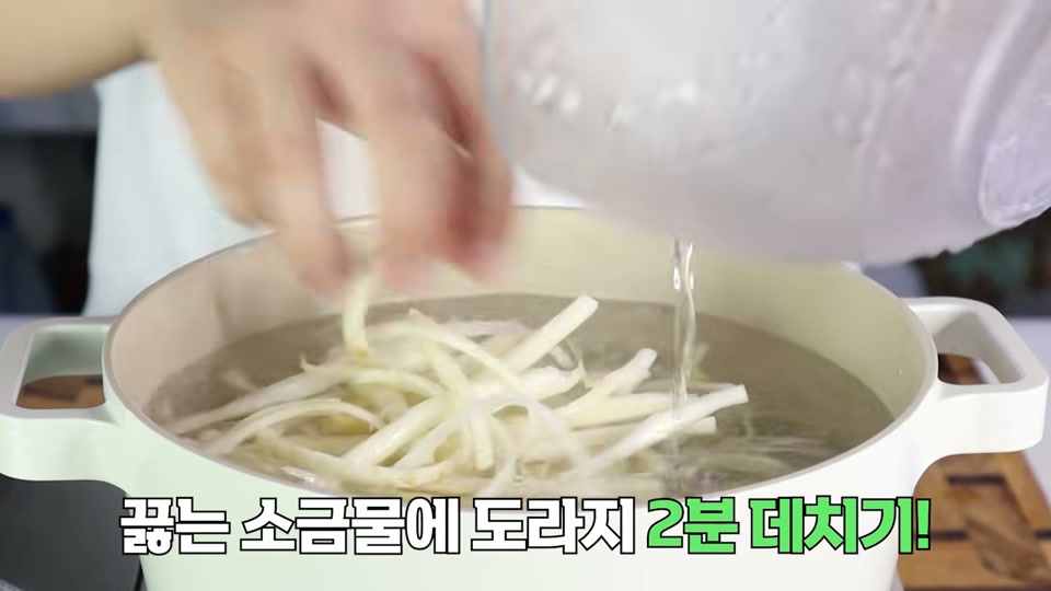 끓는 소금물에 도라지를 넣어 데치는 장면