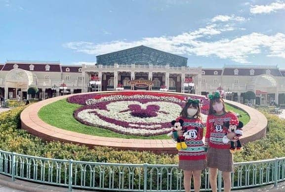 미키 마우스 모양의 잔디앞에 여성 2명이 서 있다.