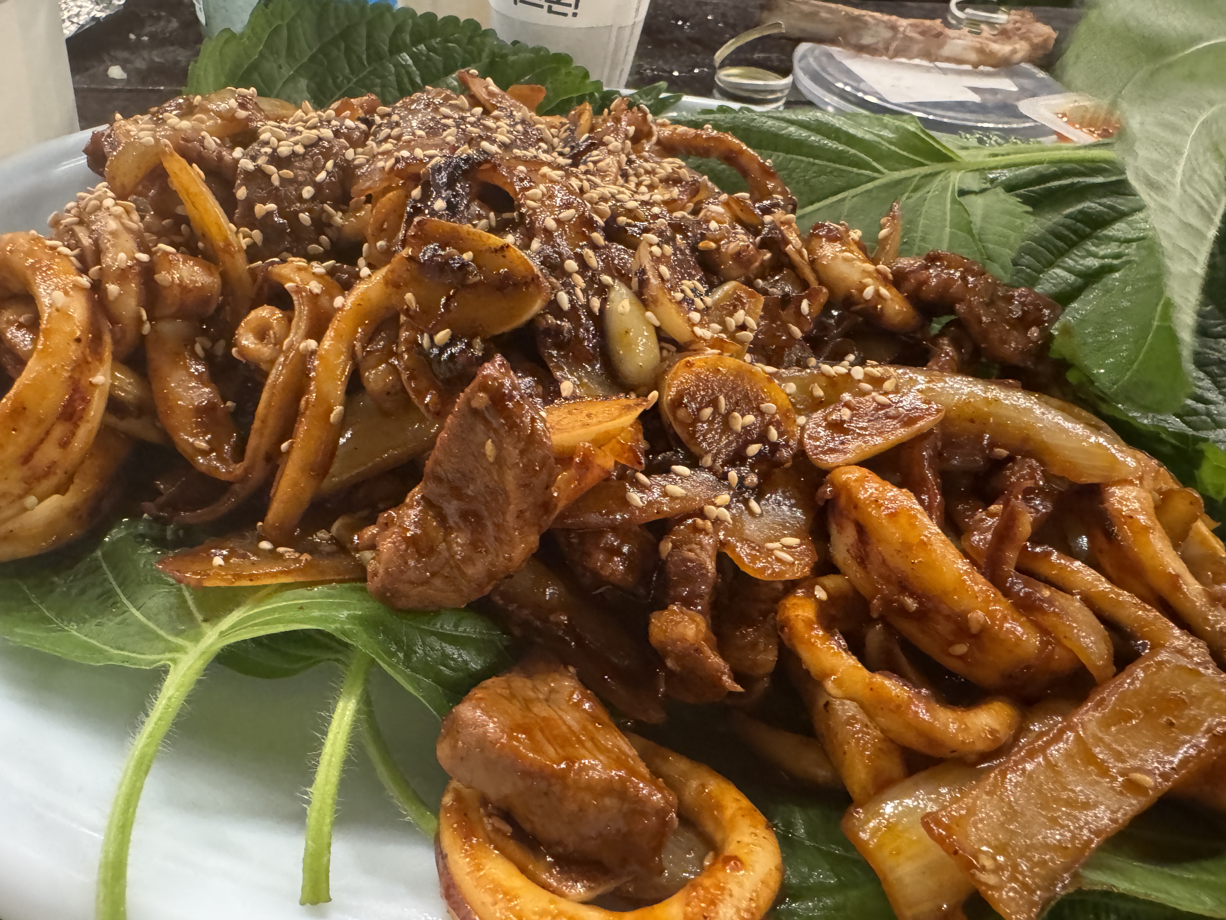 매콤하게 양념한 오징어볶음. 고추장 양념이 윤기 있게 배어 있고 깨가 솔솔 뿌려져 있어 술안주로 제격.