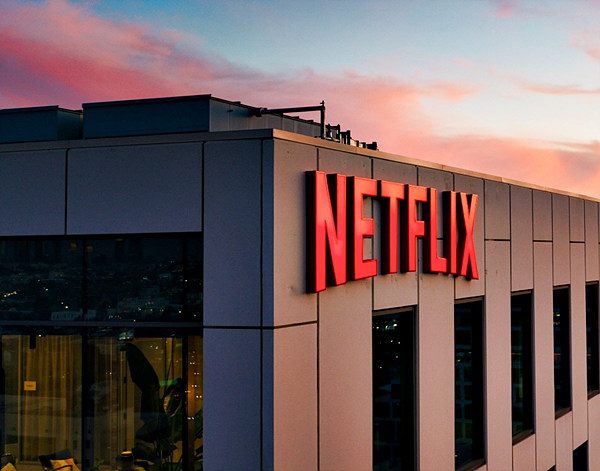 저녁노을-물드는-하늘-아래-넷플릭스-로고-간판이-있는-빌딩