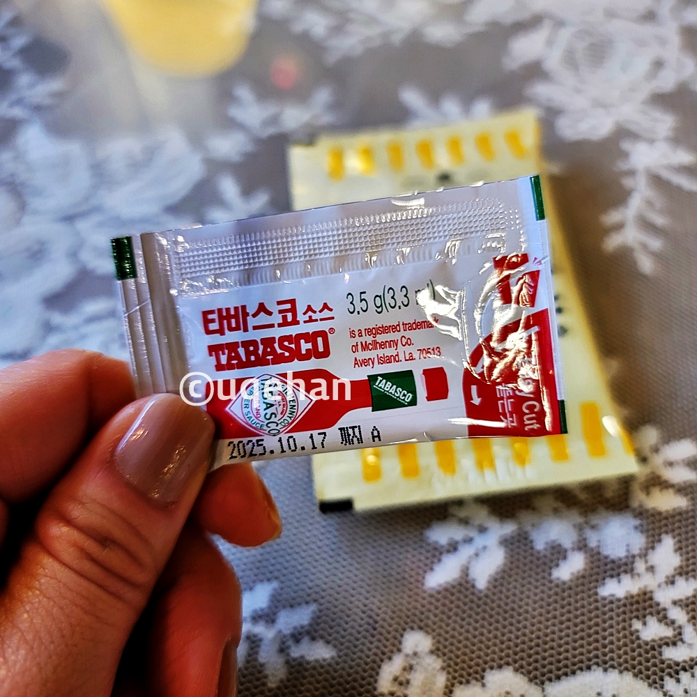 1860 조셉말린 피쉬 앤 칩스에 들어있는 타바스코 소스를 손가락으로 집고 있다.