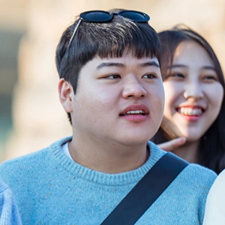 어느 실외를 배경으로 하늘색 셔츠에 썬글라스를 머리에 착용한 오늘도 사랑스럽개의 조준서 캐릭터