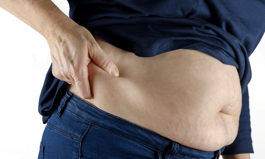 중성 지방 낮추는 방법을 찾고 있는 남자가 옆구리 살 때문에 고민하고 있다