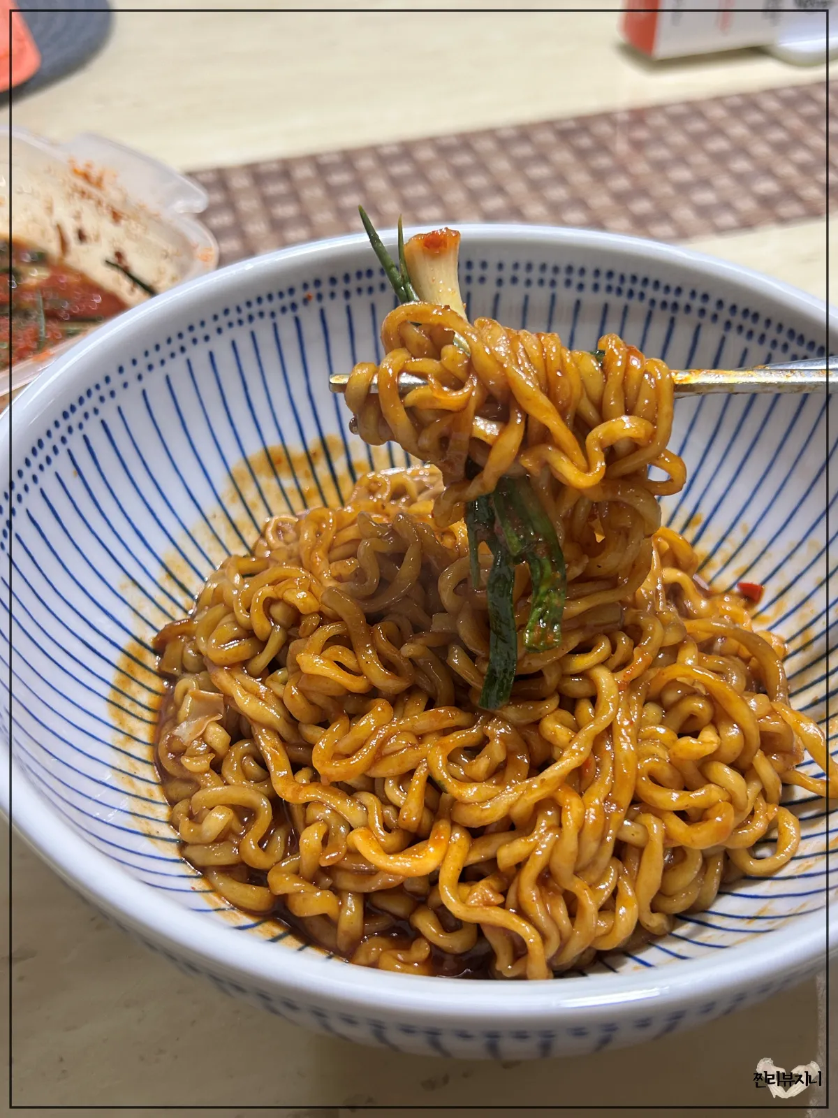 농심-마라짜파게티-완성되어-접시에-담겨진-라면과-파김치를-함께-먹는-모습