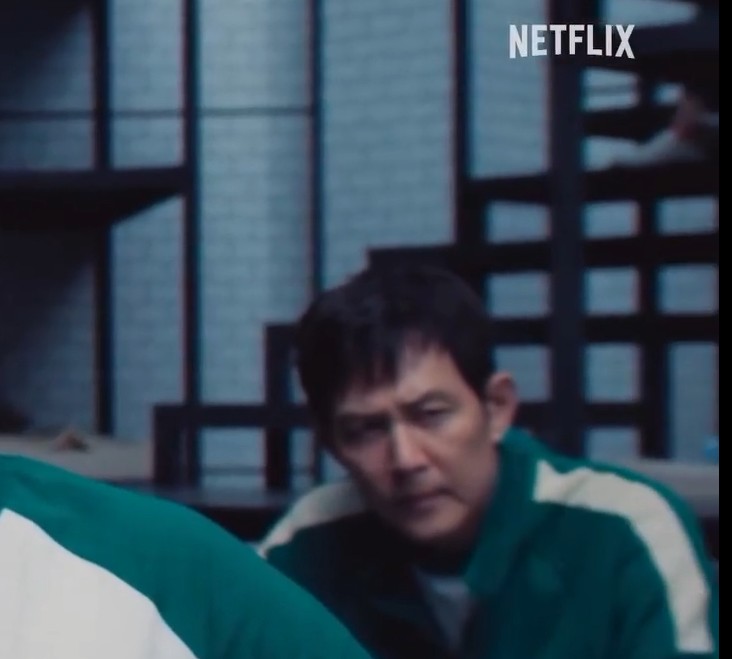 기훈(이정재)이 어두운 실내에서 침묵하며 생각에 잠긴 모습, 시즌3 분위기를 상징